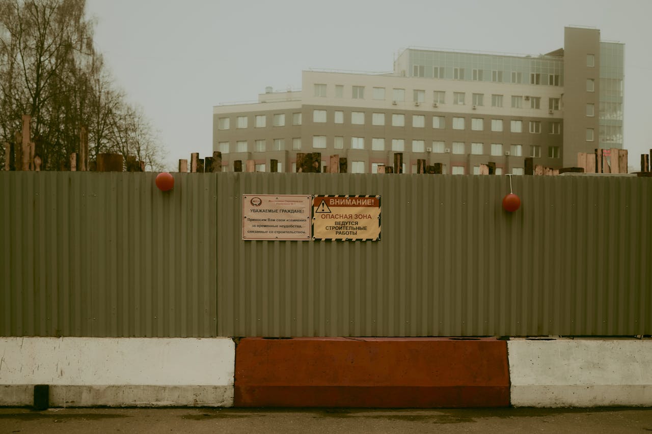 Photo of a fenced construction site with warning signs in Moscow.